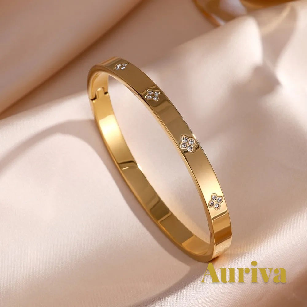 Gr8est Auriva gold-tone titanium steel bangle featuring a delicate flower pattern with pave-set cubic zirconia stones.