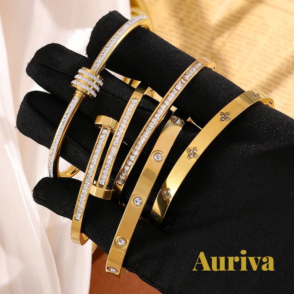 Gr8est Auriva gold titanium steel stacked bangles with cubic zirconia pave and flower accents on a gloved hand