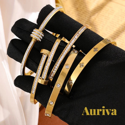 Gr8est Auriva gold titanium steel stacked bangles with cubic zirconia pave and flower accents on a gloved hand