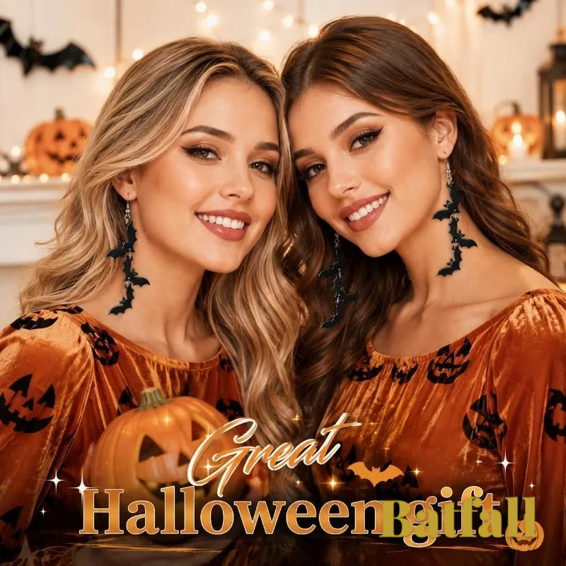 Two women wearing Gr8est black three-bat drop earrings with orange Halloween-themed tops and pumpkins in the background