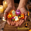 Gr8est BooGlow Halloween LED string lights with ghost, pumpkin, and mummy shapes glowing in warm white in cupped hands.