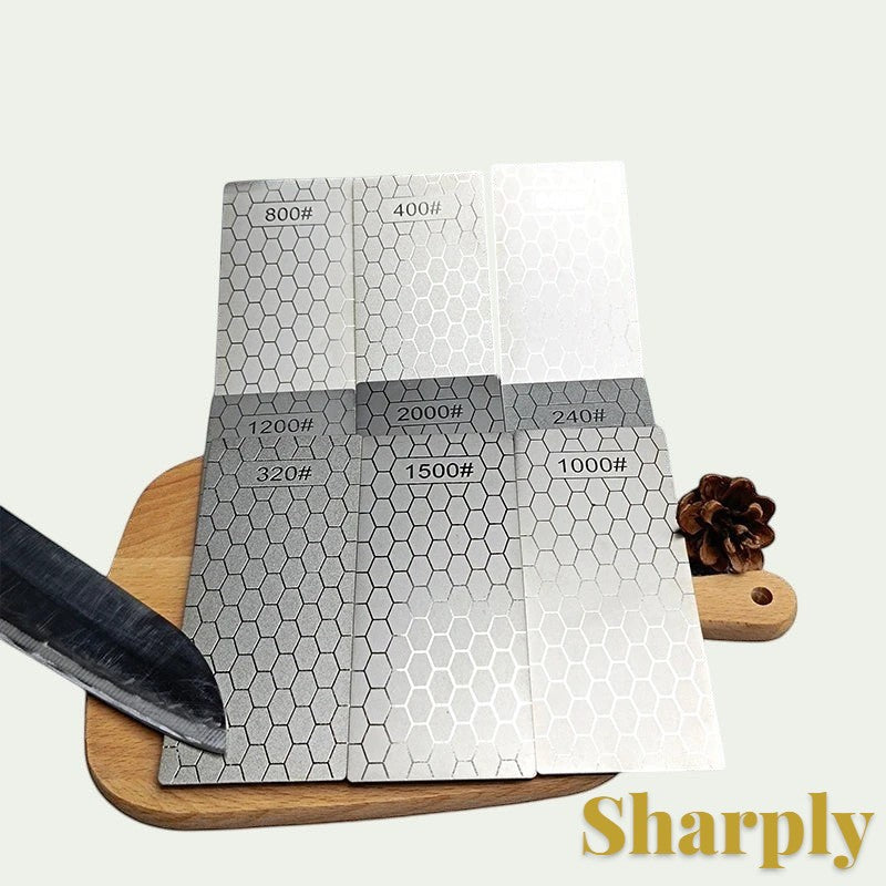 Gr8est diamond sharpening stone set with various grit levels and hexagonal patterns on a wooden board with a knife.