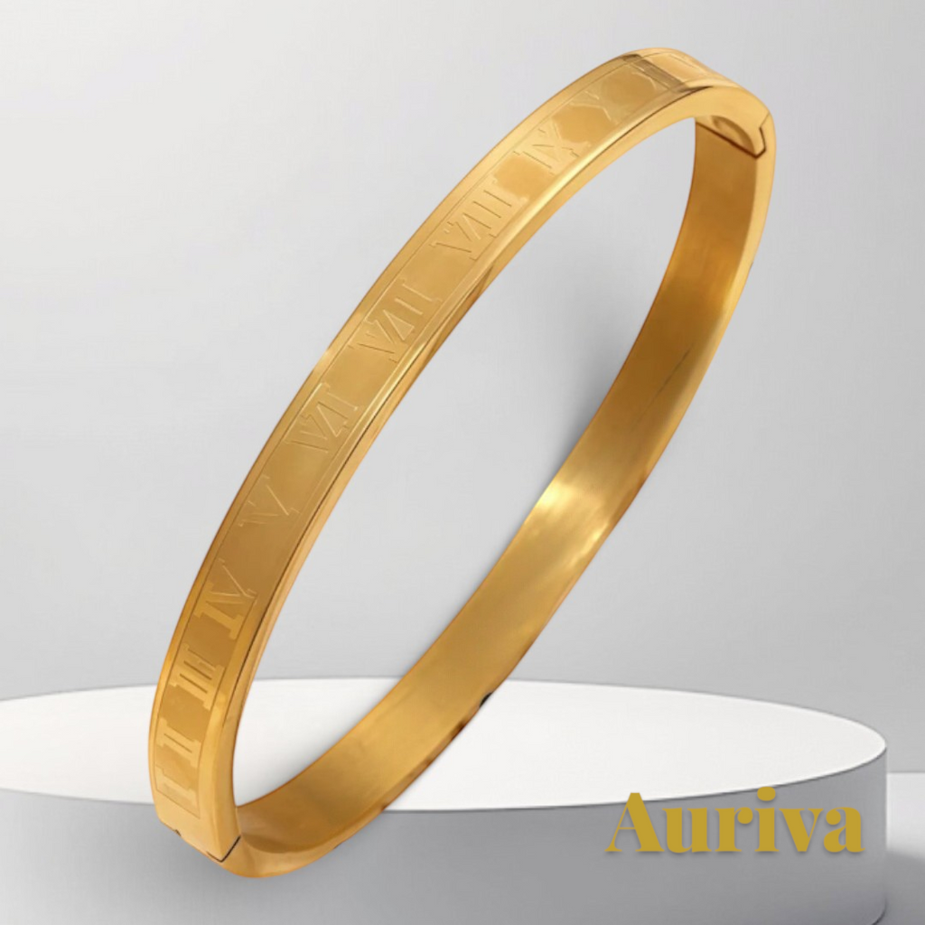 Gr8est gold stainless steel bangle bracelet featuring engraved Roman numerals on a white display pedestal