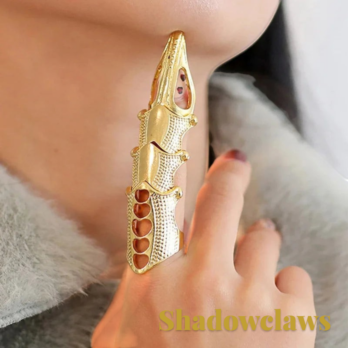 Gr8est gold-toned steampunk claw ring worn on a finger, featuring a segmented geometric design for Halloween costumes.