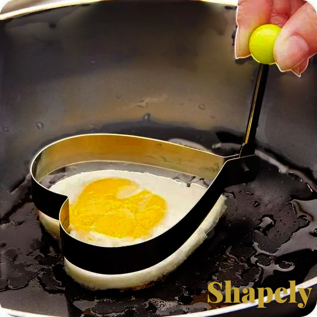 Gr8est stainless steel heart-shaped egg mold cooking ring frying a heart-shaped egg in a pan.