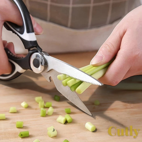 Gr8est heavy-duty kitchen shears with stainless steel serrated blades cutting green vegetables on a wooden board