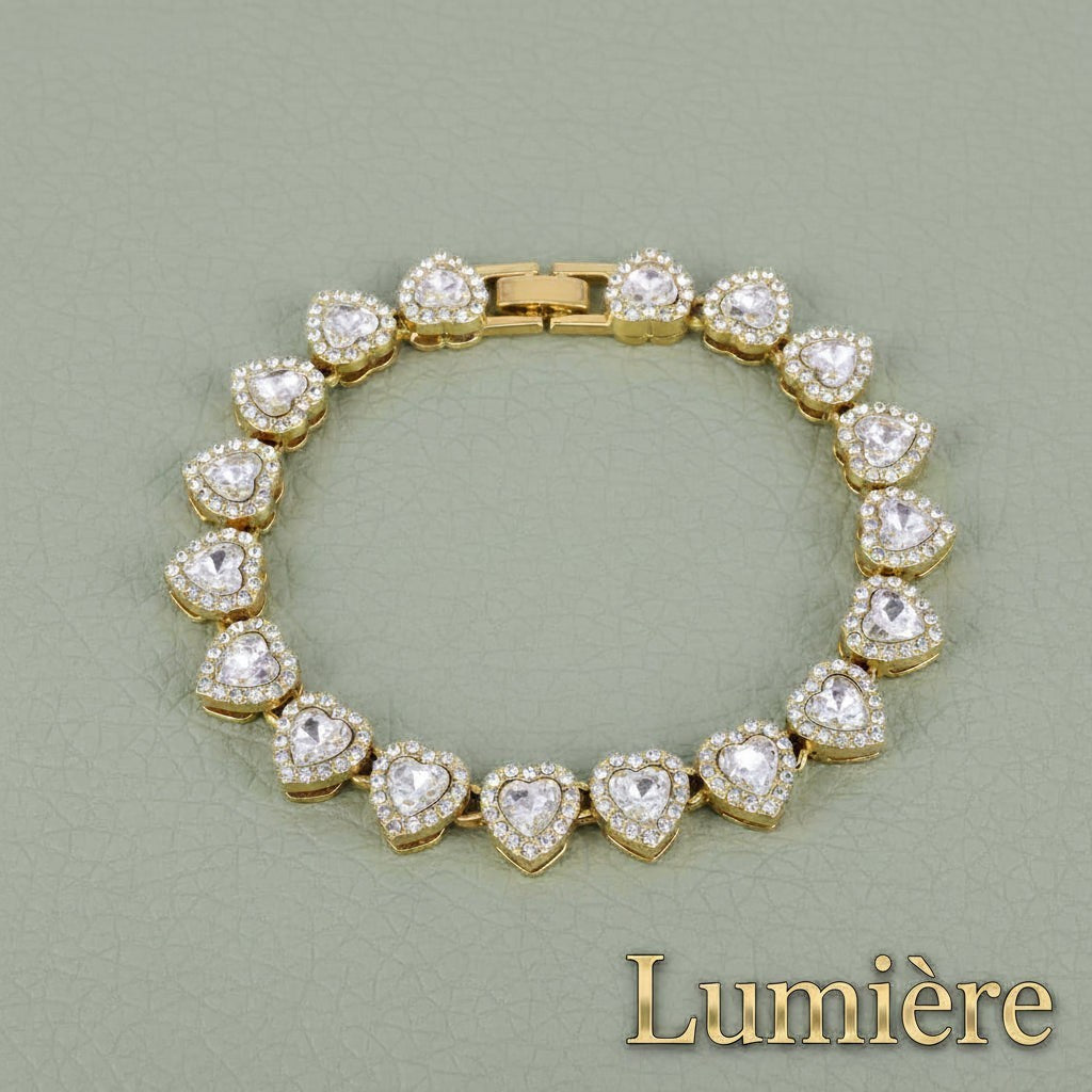 Gr8est Lumière gold-tone tennis bracelet featuring a row of sparkling heart-shaped rhinestones on a zinc alloy chain.