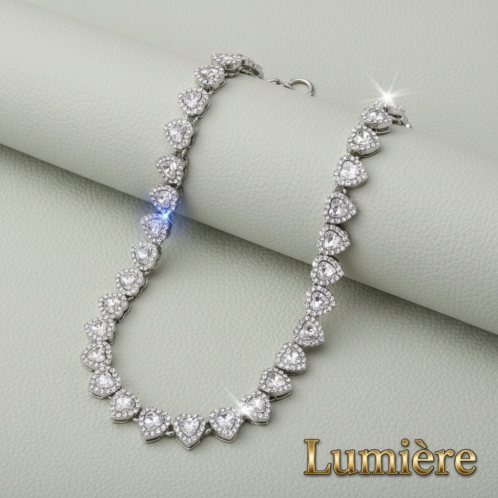 Gr8est Lumière silver heart tennis necklace with sparkling rhinestones on a textured grey background