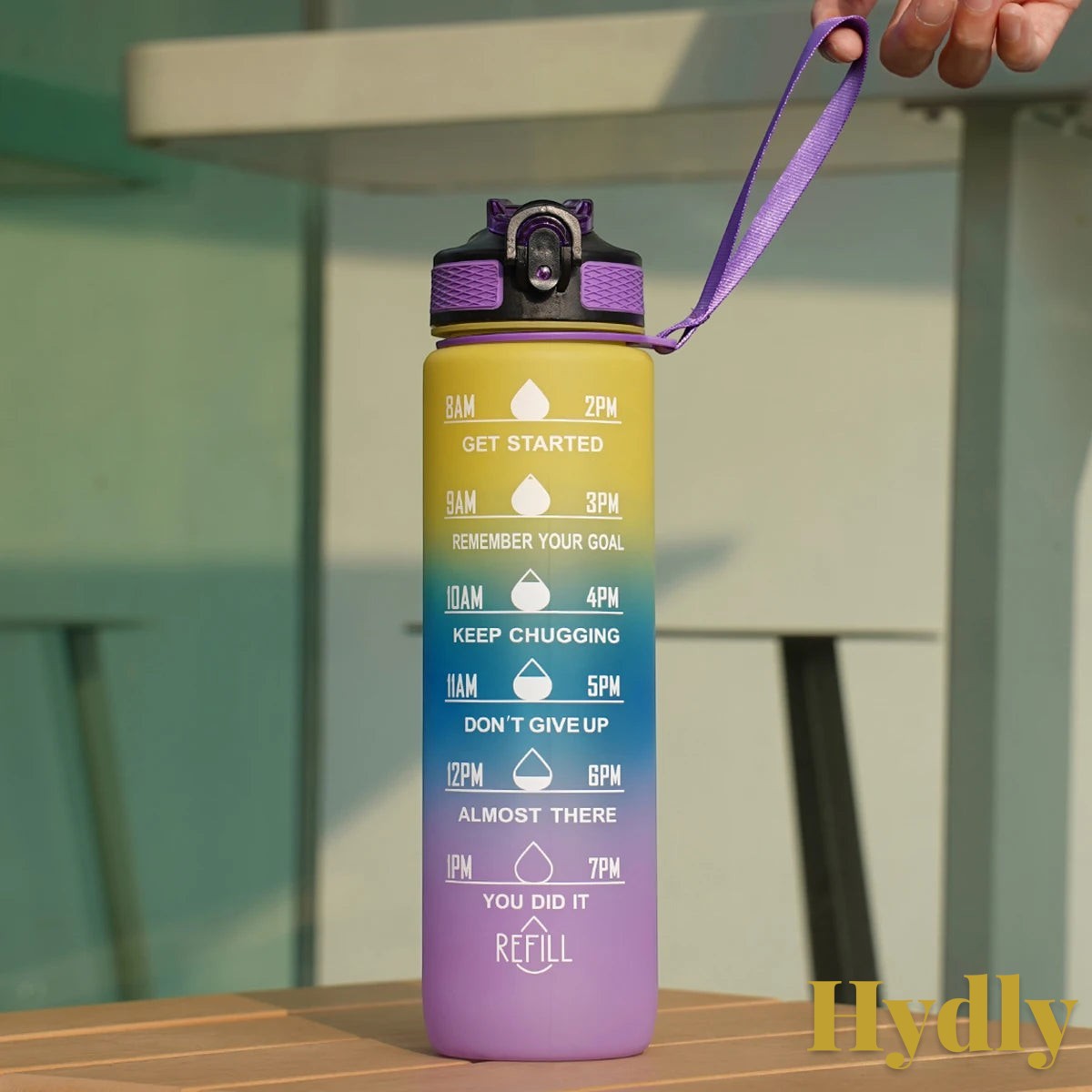 Gr8est 1L motivational water bottle in a yellow to purple gradient with time markers and a purple carry strap.
