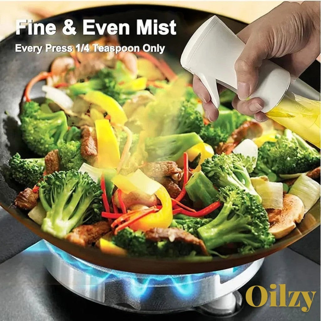 Gr8est Oilzy kitchen oil spray bottle misting olive oil over a pan of stir-fried vegetables on a gas stove