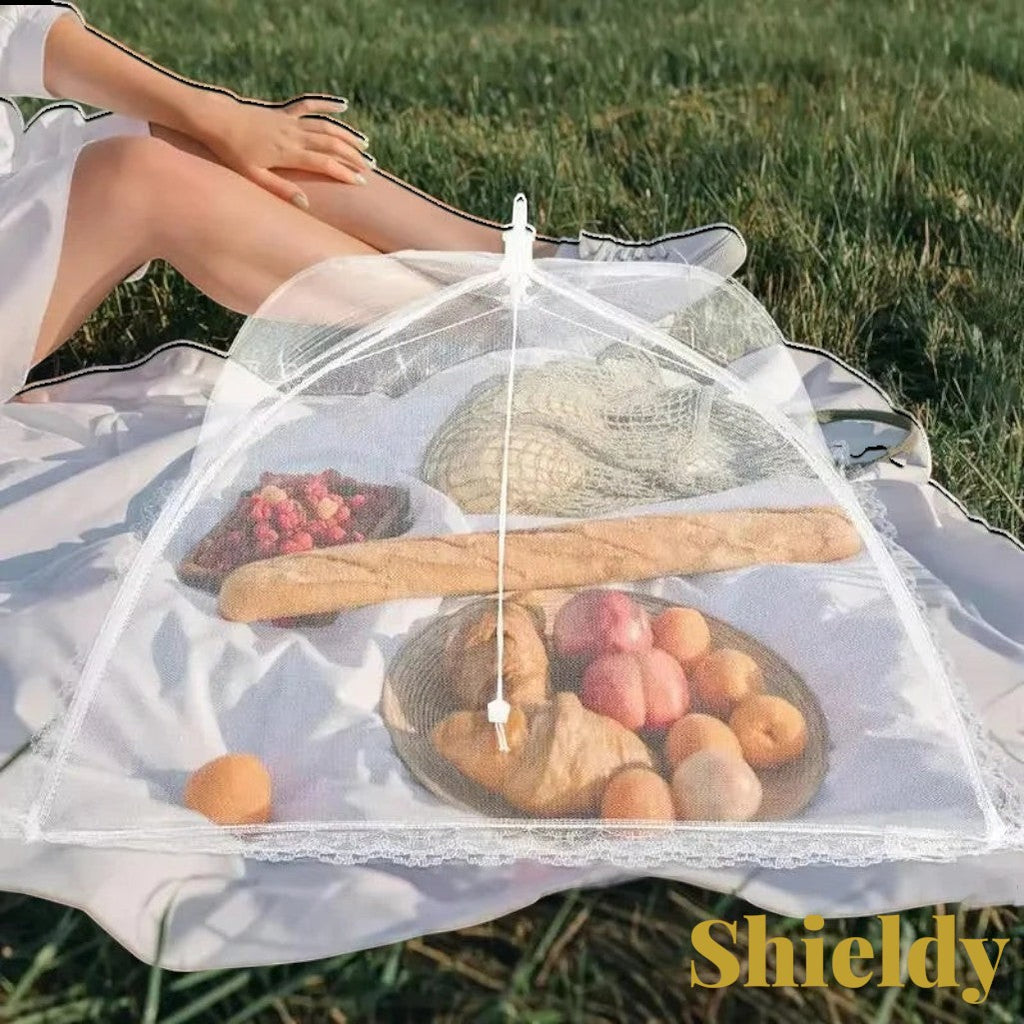 Gr8est white pop-up mesh food cover protecting bread and fruit on a picnic blanket in a sunny outdoor setting