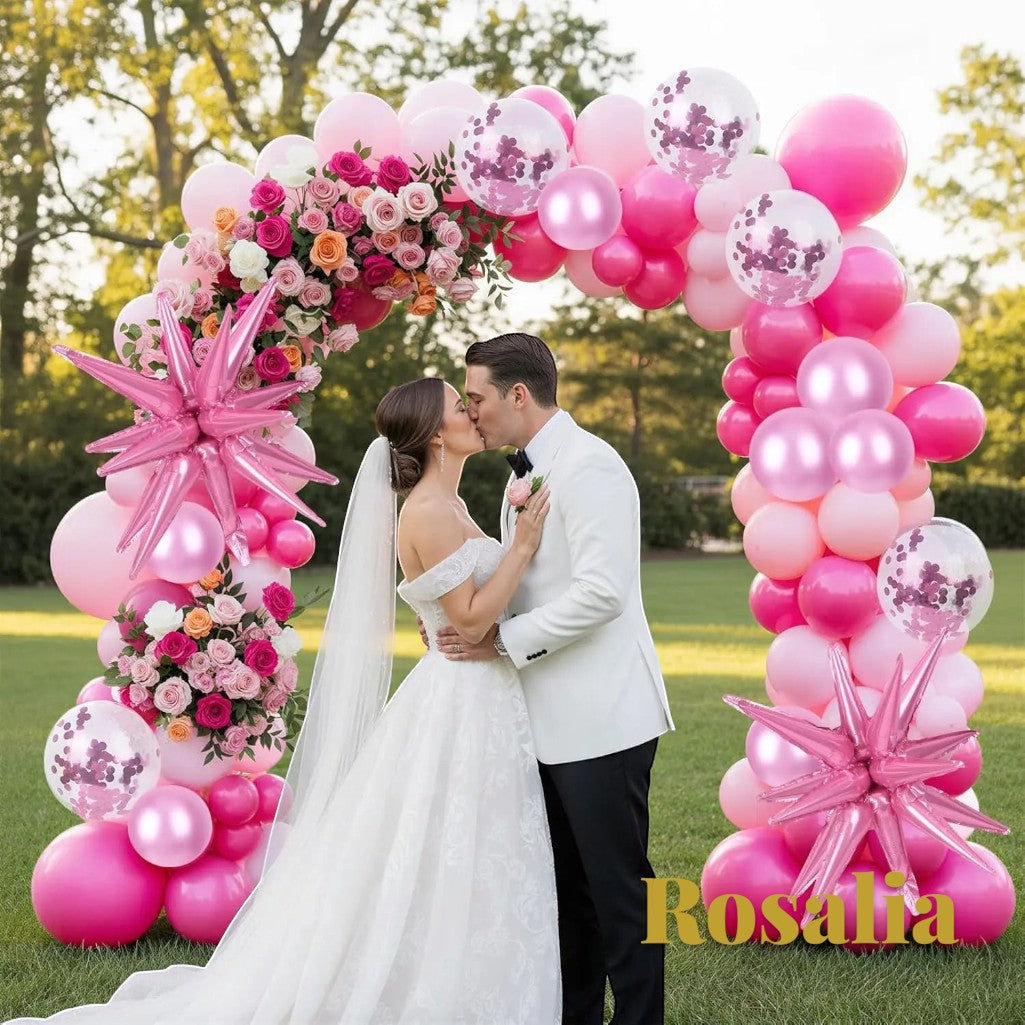 Gr8est Rosalia pink balloon arch kit with star and round latex balloons framing a bride and groom at an outdoor wedding