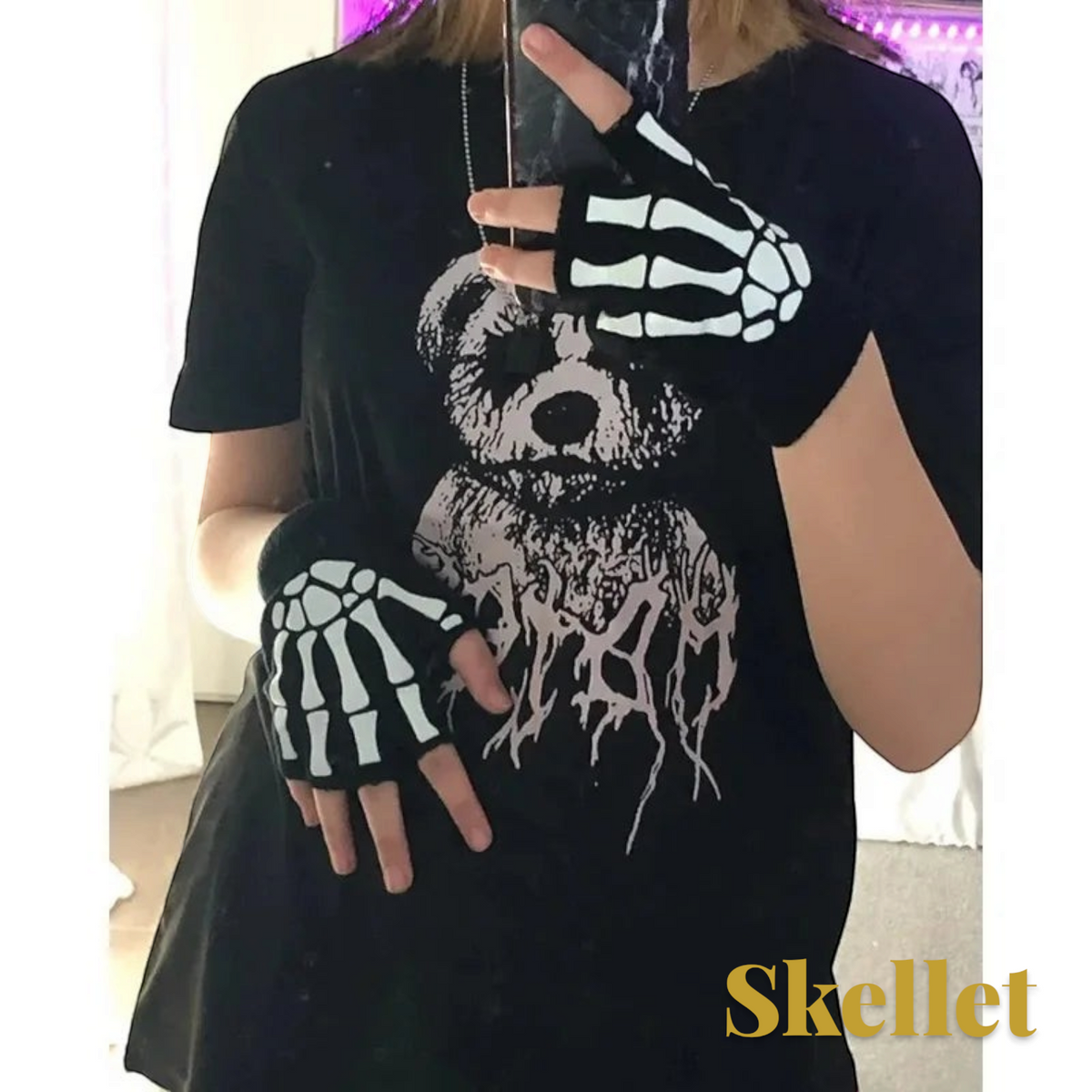 Gr8est Skellet black fingerless gloves with white skeleton hand bone print worn by a person in a black graphic t-shirt.