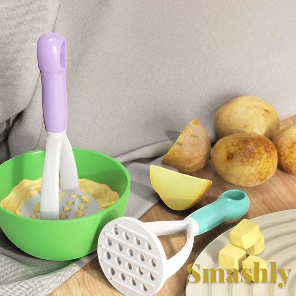 Gr8est Smashly potato masher and peeler tools in purple and teal plastic, used for mashing potatoes in a green bowl.