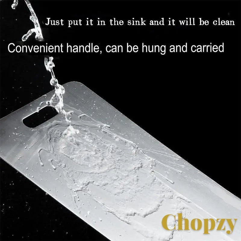 Gr8est stainless steel cutting board being rinsed in a sink, showing its durable, hygienic surface and carry handle.