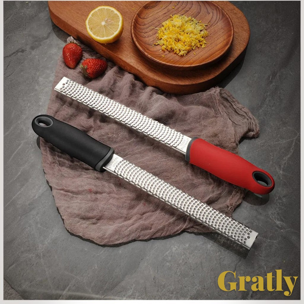 Gr8est stainless steel multi-purpose graters with black and red ergonomic handles on a rustic kitchen surface
