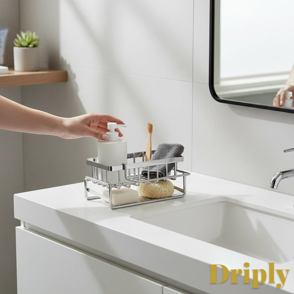 Gr8est stainless steel sink caddy holding soap, toothbrush, and sponge on a white bathroom vanity.