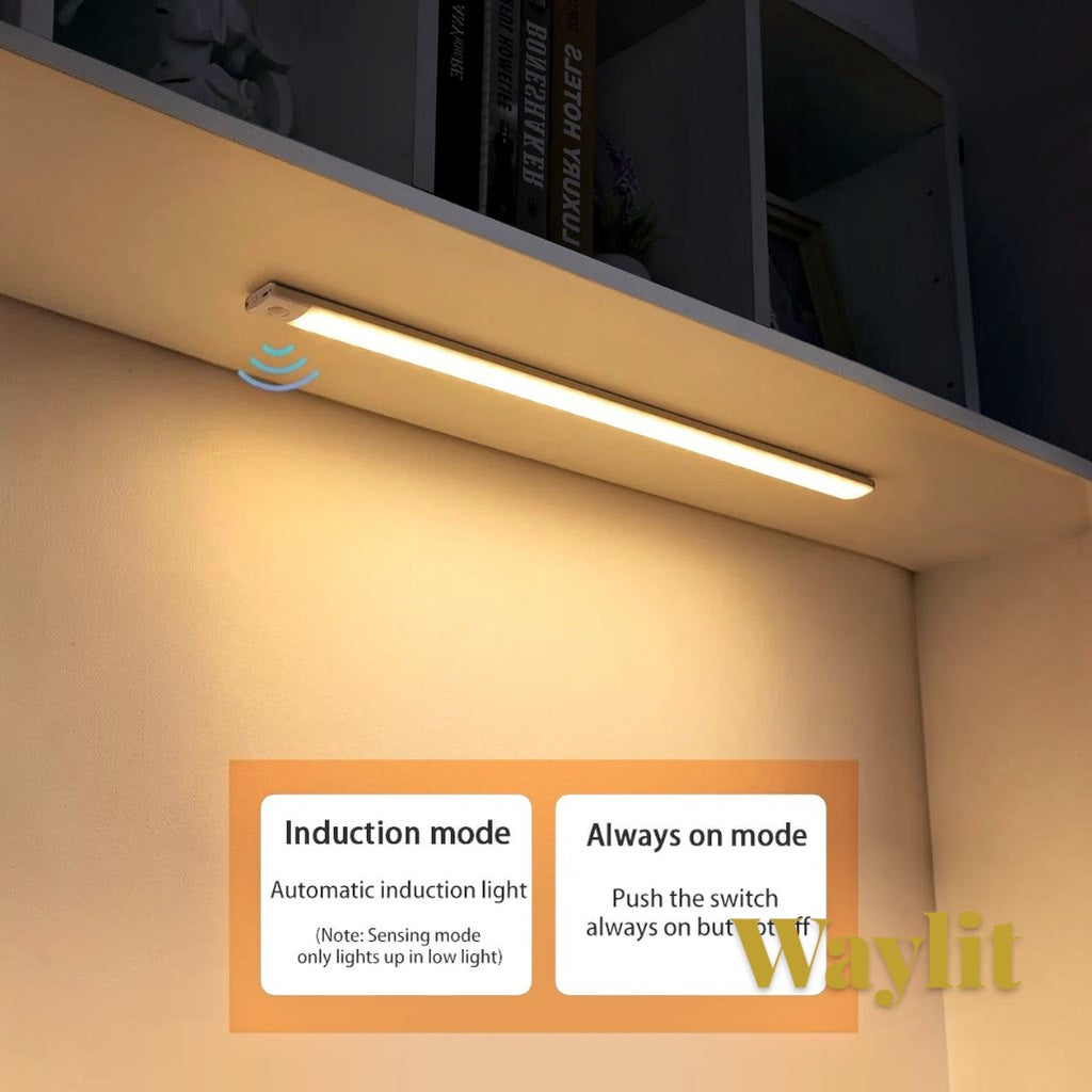 Gr8est Waylit motion sensor LED bar light mounted under a shelf, emitting a warm glow in a kitchen or cabinet setting.