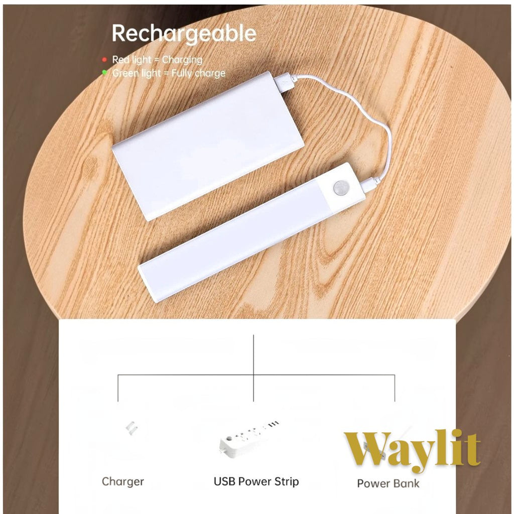 Gr8est Waylit motion sensor LED bar light being charged by a power bank on a wooden table with USB charging options.