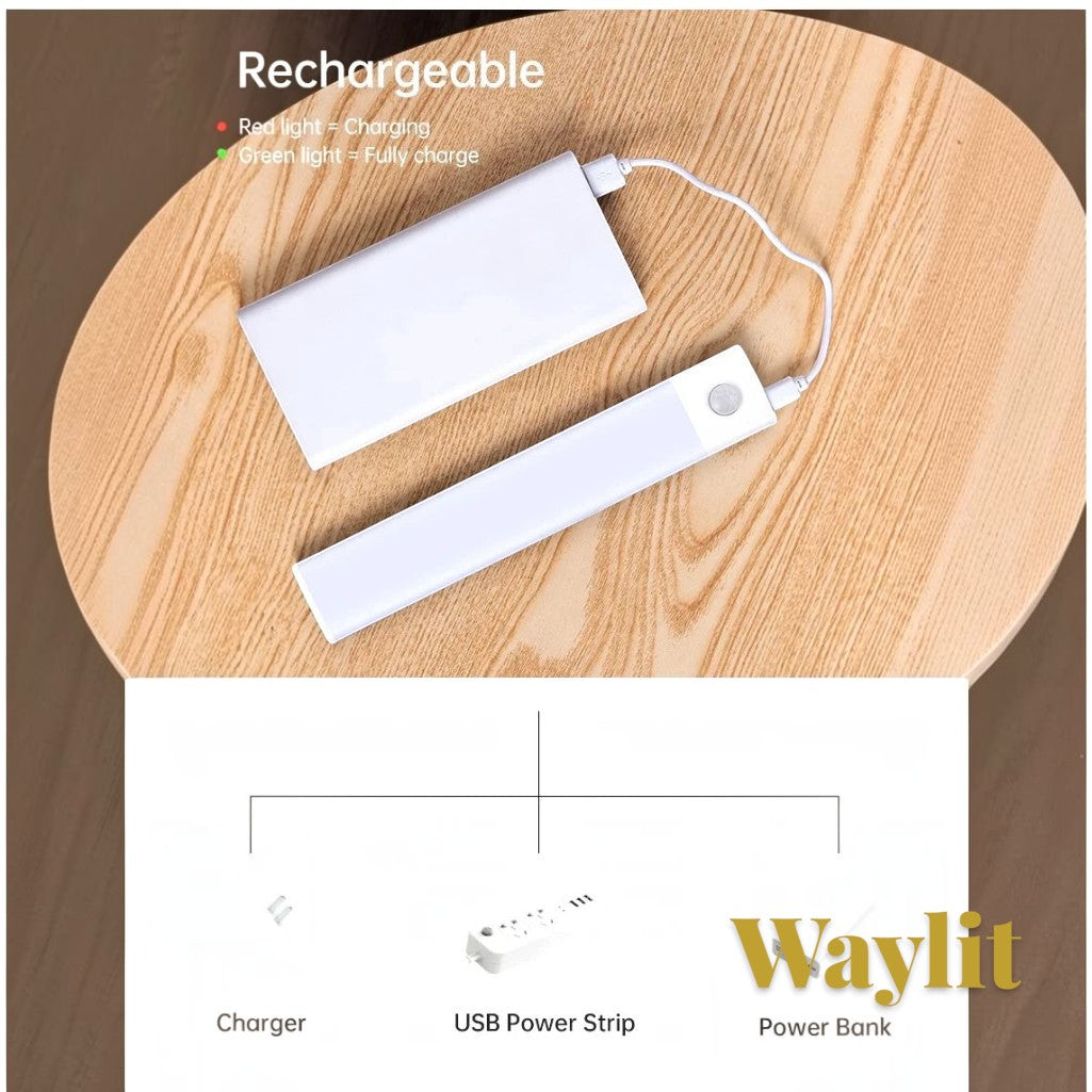 Gr8est Waylit motion sensor LED bar light being charged by a power bank on a wooden table with USB charging options.