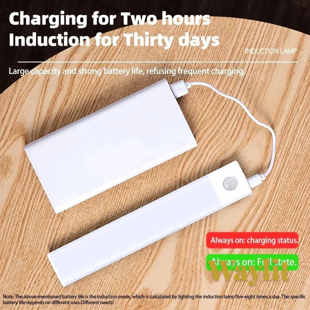 Gr8est Waylit rechargeable motion sensor LED bar light being charged with a USB cable on a wooden table.