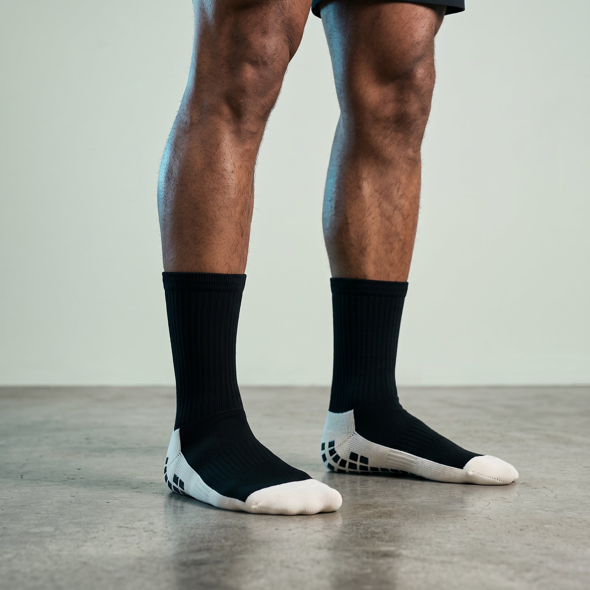 Studio photo of GripX Lower body front view, one foot on slight elevation, showing fit and length. CAMERA SHOT: A FULL BODY shot capturing the person from head to toe. [Upper body focus]